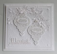 a white christmas card with two ornaments on it