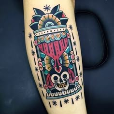 a colorful tattoo on the leg of a person with a skull and heart in it