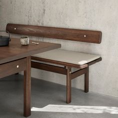 a wooden bench sitting next to a table