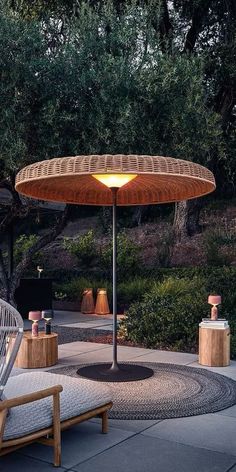 an umbrella shaped table sitting on top of a cement floor next to a park bench