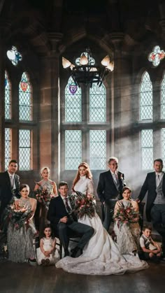 a group of people standing next to each other in front of two stained glass windows