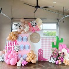 balloons and decorations are on display in front of a backdrop for a baby's first birthday