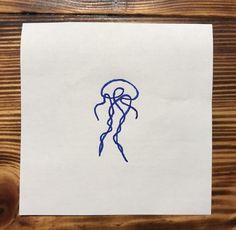 a piece of paper with a drawing of a jellyfish on it's side