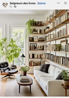 a living room filled with lots of furniture and bookshelves full of books on the wall