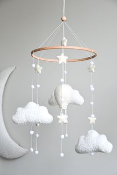 a baby crib mobile with stars and clouds hanging from it