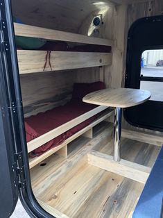 the inside of a camper with bunk beds and tables in it's back