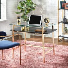 a desk with a computer on top of it in front of a book shelf and window