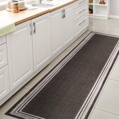 a kitchen area with white cabinets and gray rugs on the floor, along with two sinks