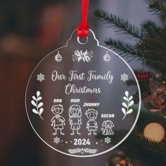 a christmas ornament hanging on a tree with ornaments around it and the words our first family christmas