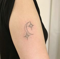 a woman's arm with a crescent and star tattoo on the left side of her arm