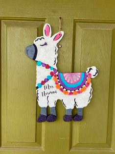 a llama door hanger hanging on a green door