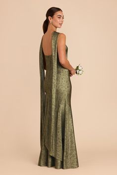 the back of a woman in a long green dress with an open back and floral bouquet