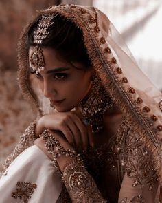 a woman wearing a bridal veil and holding her hand on her shoulder, in an artistic photo