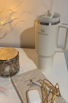 a white coffee cup sitting on top of a table next to a pair of glasses