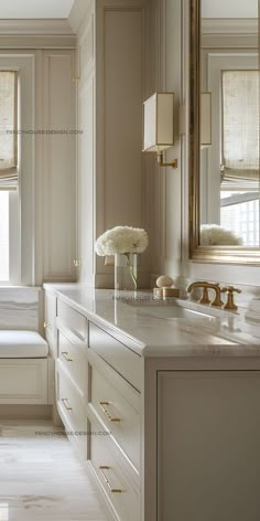 a white bathroom with marble counter tops and drawers, along with two large mirrors on the wall