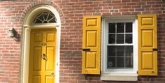 a yellow door and window on a brick building