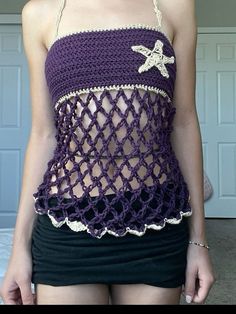 a woman wearing a purple crocheted tank top with starfish on the front