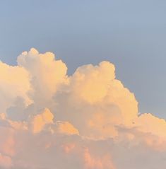 the plane is flying high in the sky with clouds behind it and an airplane on the ground below