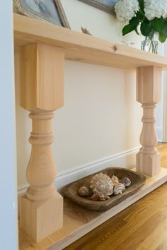 a wooden shelf with seashells and flowers on it