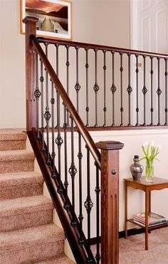 a stair case next to a table with flowers on it