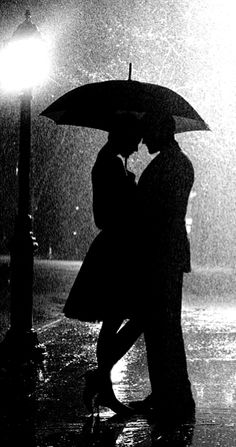 a couple kissing under an umbrella in the rain