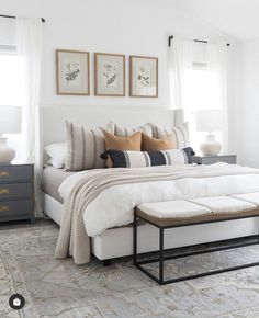 a large bed sitting next to two windows in a bedroom on top of a rug