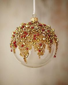 a christmas ornament hanging from a string with beads and chains on it's side