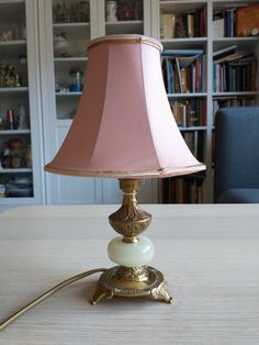 a pink lamp sitting on top of a wooden table