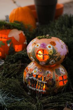 some pumpkins with lights on sitting in the grass