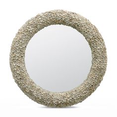 a circular mirror made out of rocks on a white background