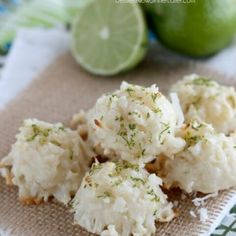 some food that is sitting on top of a cloth next to lemons and lime wedges