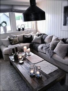 a living room filled with lots of furniture and candles on top of a coffee table