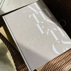 an open book sitting on top of a wicker chair