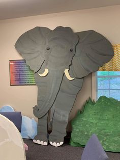 an elephant made out of foam sitting on the floor in front of a child's playroom