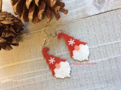 some pine cones are sitting on a table next to two knitted christmas stocking