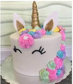 a cake decorated with flowers and a unicorn's face