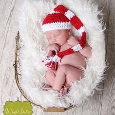 a newborn baby wearing a red and white knitted hat