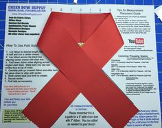 an origami piece of paper with a red ribbon on it and instructions for how to fold