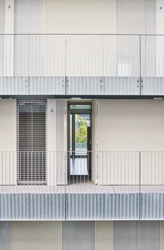 an apartment building with two balconies and one door open to the balcony area