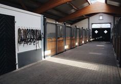 the inside of a horse barn with stalls and tacks hanging on the side of the building