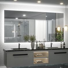 a bathroom with two sinks and a large mirror over it's counter top area