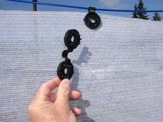 a hand is holding an object in front of a blue and white fabric with donuts on it