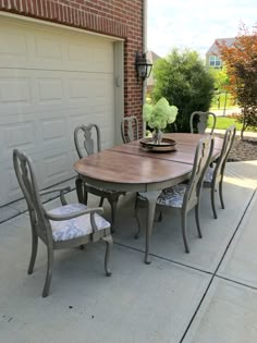 a wooden table with chairs around it in front of a garage door