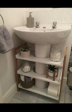 a white sink sitting under a bathroom mirror next to a shelf filled with toiletries