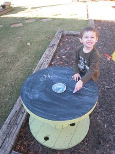 a young boy sitting on top of a black and yellow table