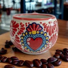 a coffee cup sitting on top of a wooden table next to roasted up coffee beans