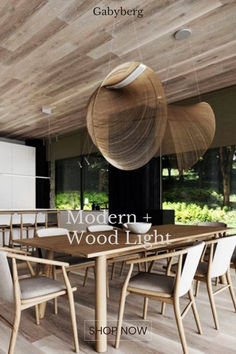 the modern and wood light is hanging from the ceiling in this dining room with white chairs