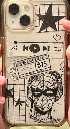 someone holding up their phone case with some drawings on it