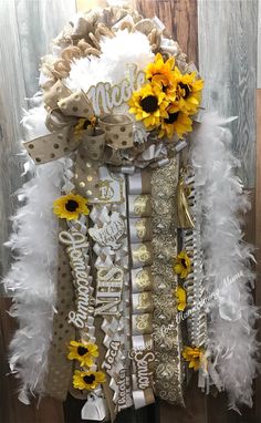 a white and gold wreath with sunflowers on it