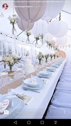 an image of a table set up for a wedding reception with paper lanterns hanging from the ceiling